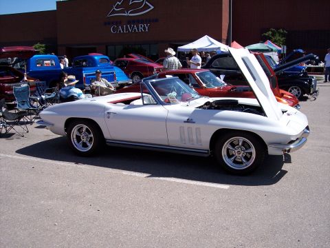 1972 Ford Ranchero - A white 1965 convertible is displayed with its hood open at a car show in front of Rocky Mountain Calvary Church.