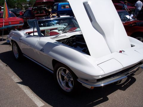 1972 Ford Ranchero - A white convertible sports car is displayed with its hood open at an outdoor gathering, surrounded by other vehicles.