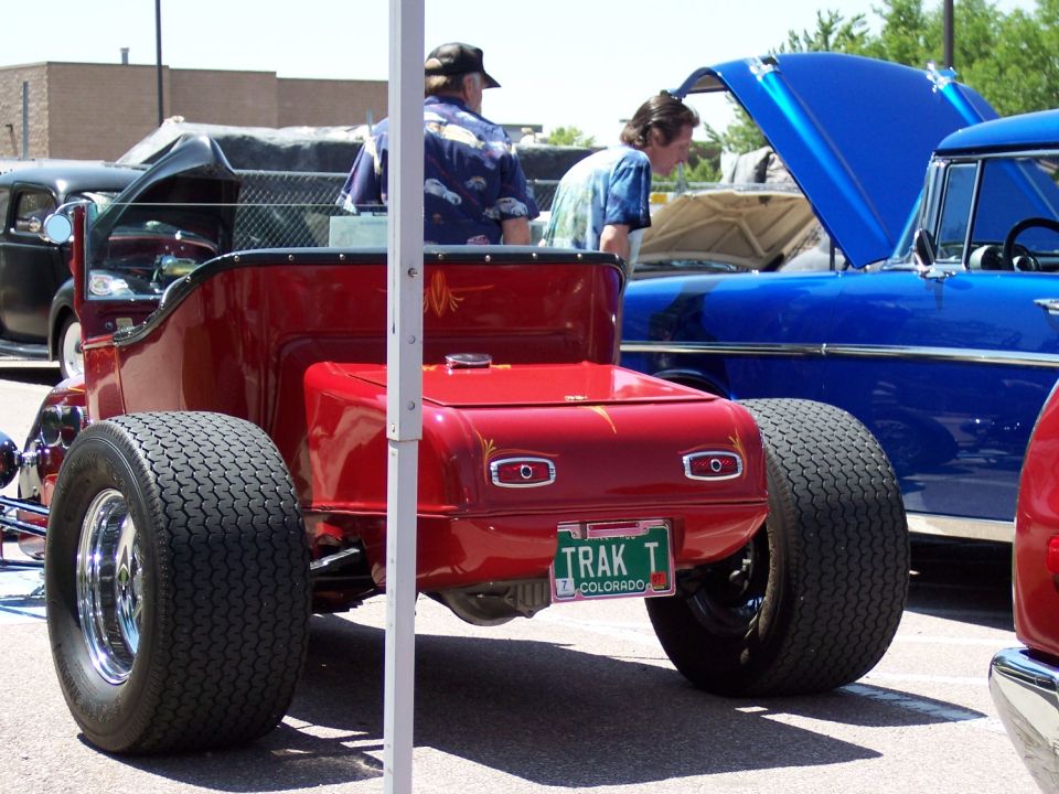 Red hot rod rear view with wide tires and Colorado license plate reading TRAK T