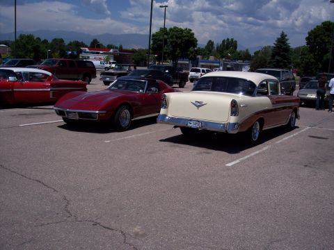 1972 Ford Ranchero - A two-tone 1956 Chevrolet sedan is parked next to a red sports car in a parking lot.