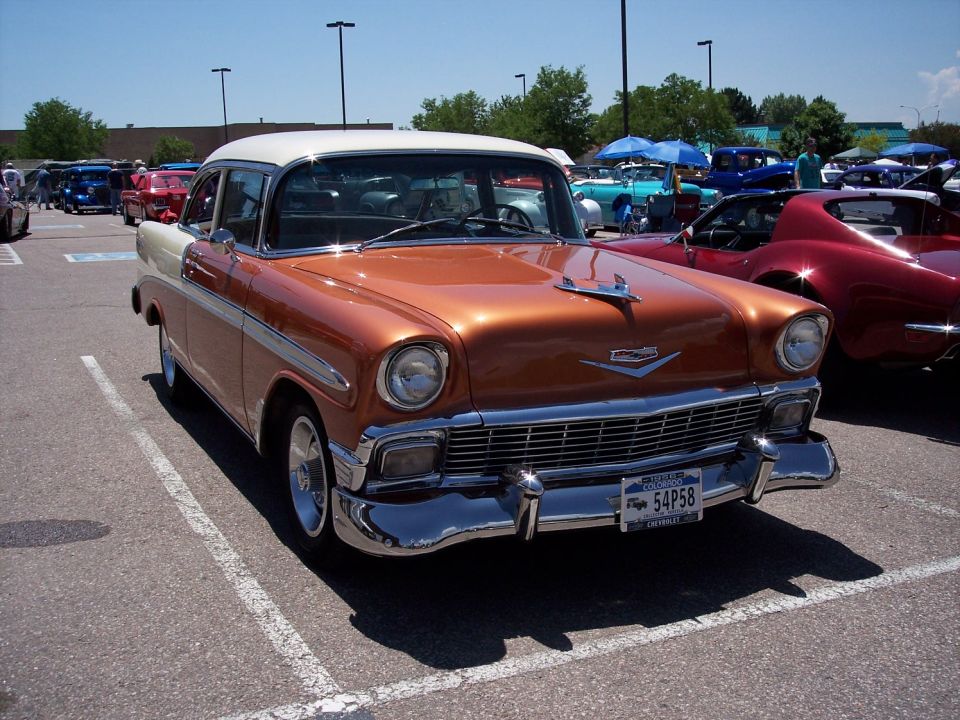 Orange and white 1956 Chevrolet sedan, front 3/4 view. License plate 54P58