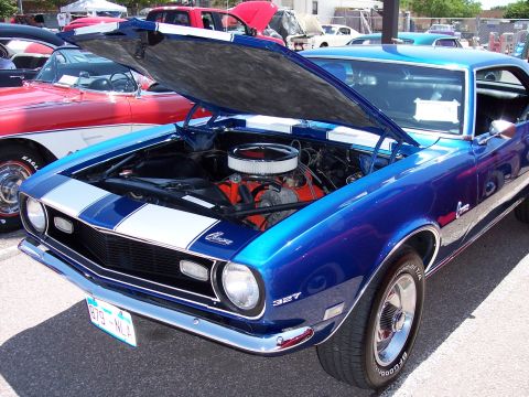 1972 Ford Ranchero - 1969 Chevrolet Camaro with its hood open, parked next to a red car.