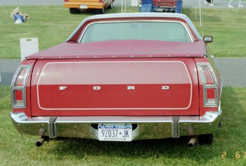 1976 Ford Ranchero - The rear of a red Ford Ranchero pickup truck is shown, with a New York license plate and "FORD" spelled out across the tailgate.