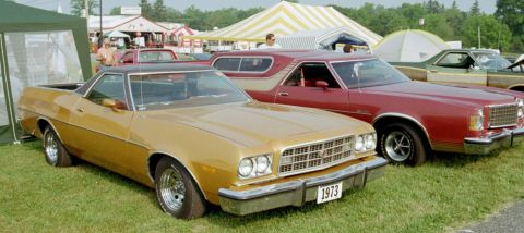 1976 Ford Ranchero - A gold 1973 Ford Ranchero is parked next to a red Ranchero and other vehicles at an outdoor event.