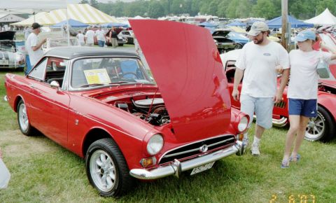 1976 Ford Ranchero - A red convertible is displayed with its hood open at an outdoor event.