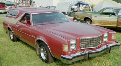 1976 Ford Ranchero - A red 1976 Ford Ranchero pickup truck with a camper shell is parked on grass, with another vehicle visible in the background.