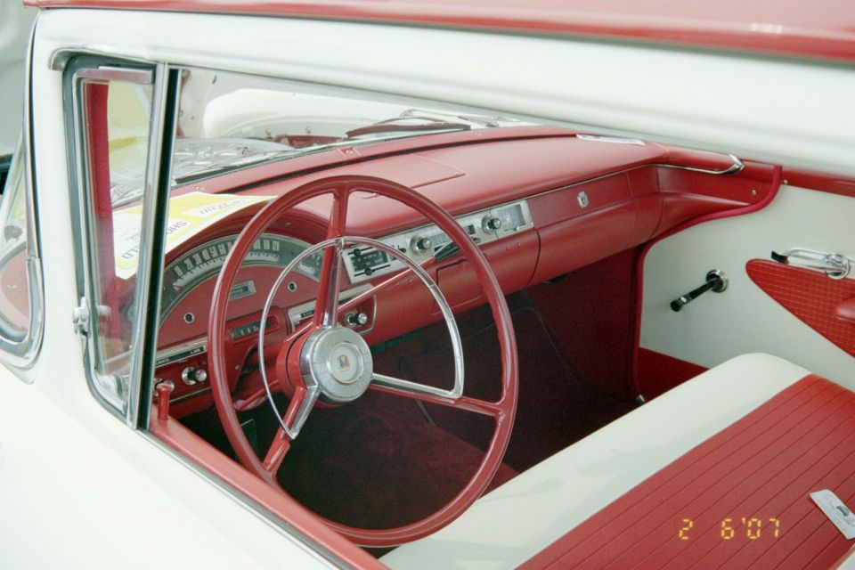 Red and white car interior with a large red steering wheel and dashboard