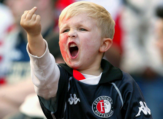 Young blond child in Feyenoord Rotterdam soccer jersey shouting at a match