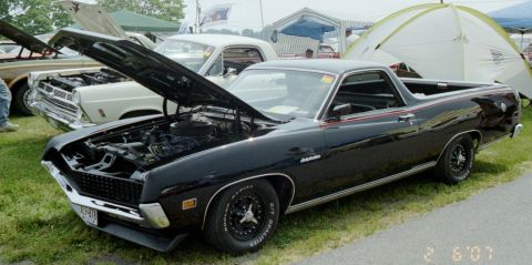 1976 Ford Ranchero - A black Ford Ranchero is displayed with its hood open, parked next to another vehicle at an outdoor event.