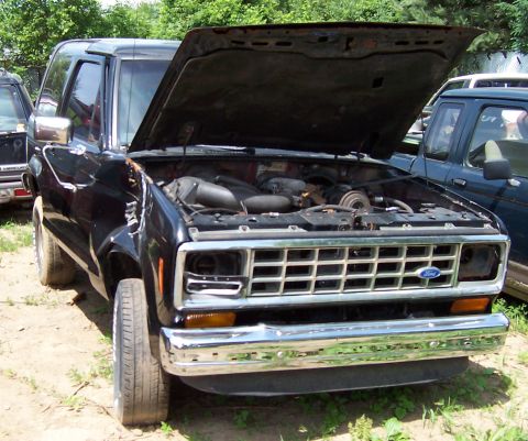 1980 Jeep CJ5 - This black Ford Bronco II has its hood open, revealing the engine compartment. Another vehicle is visible to the right.