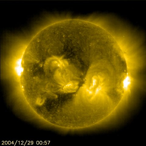 1990 Ford Bronco - SOHO-style ultraviolet solar observatory image of the Sun in false-color yellow, showing bright active regions and coronal loops against bl…