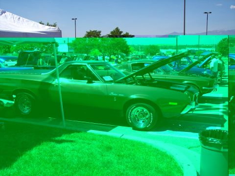 1972 Ford Ranchero - A green 1972 Ford Ranchero is parked with its hood open, alongside other vehicles at an outdoor event.