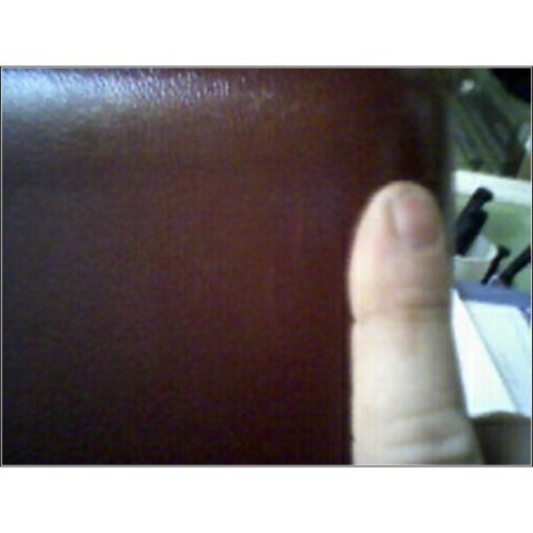 1973 Ford Ranchero - A close-up view shows a brown textured surface and a thumb, with office supplies in the background.