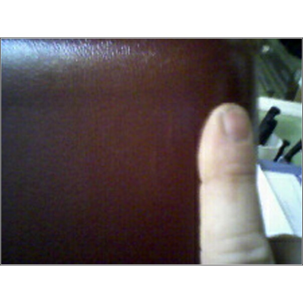 Brown textured surface with a thumb on the right