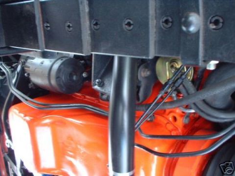 1978 Ford E250 - A close-up view of engine components, including an orange oil pan and black hoses.