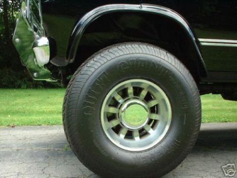 1978 Ford E250 - Close-up of a 1978 Ford E250's front wheel and fender assembly, highlighting its chrome bumper and alloy wheel.