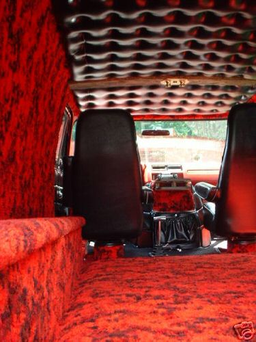 1978 Ford E250 - The interior of a van features vibrant red carpet and black upholstered seats, with a uniquely textured ceiling.