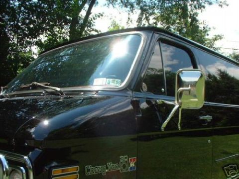1978 Ford E250 - A black van is parked outside with trees in the background. A license plate is visible on the windshield.