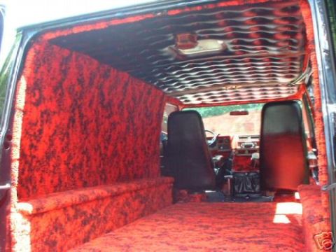 1978 Ford E250 - The interior of a van features custom red shag carpeting and a flame-patterned headliner.