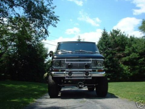1978 Ford E250 - Front view of a black 1978 Ford E250 van with a lifted suspension and custom grille.