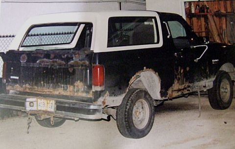 1988 Ford Bronco - This 1988 Ford Bronco shows significant rust damage on its body panels and rear tailgate.