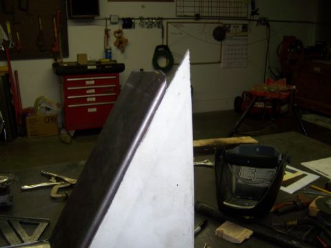 1991 Ford Bronco - A metal panel project is underway in a garage, surrounded by tools and equipment.