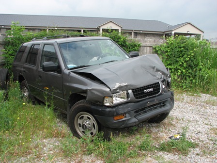 1991 Ford Bronco - This Isuzu Trooper has significant front-end damage and is parked in a grassy area.