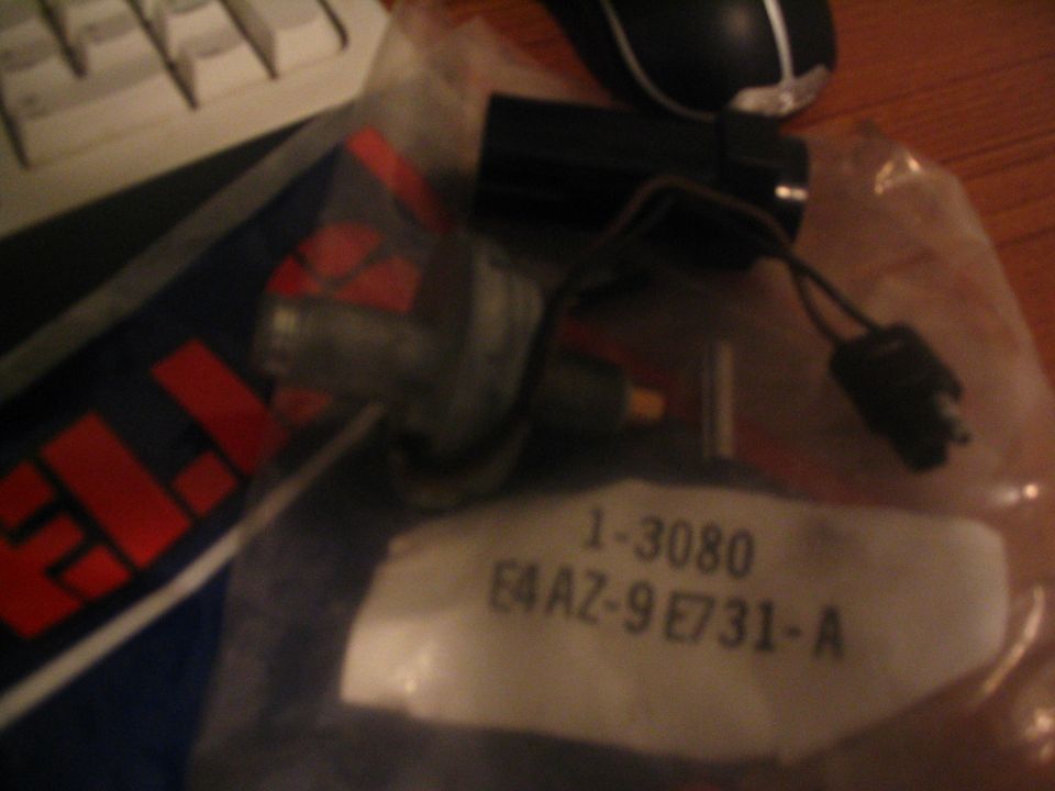 Bagged Ford part E4AZ-9E731-A sensor with pigtail connector on desk