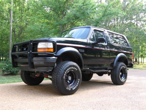 1967 Ford Mustang - This black Ford Bronco features a bull bar and red pinstripes, seen from a 3/4 front angle.