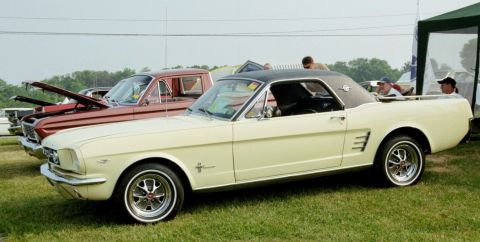 1976 Ford Ranchero - A cream-colored 1965 Ford Falcon Ranchero coupe utility is displayed on a grassy field next to other vehicles.