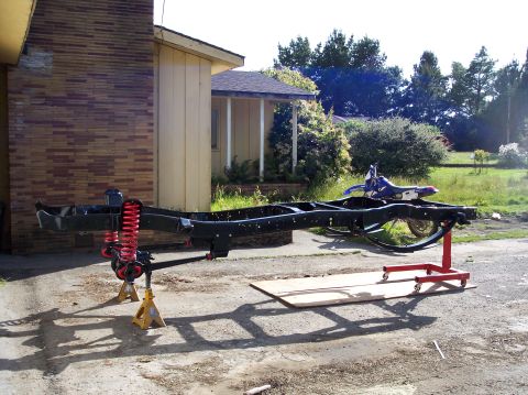 1977 Ford F-150 - Truck frame undergoing work, with a dirt bike visible in the yard.
