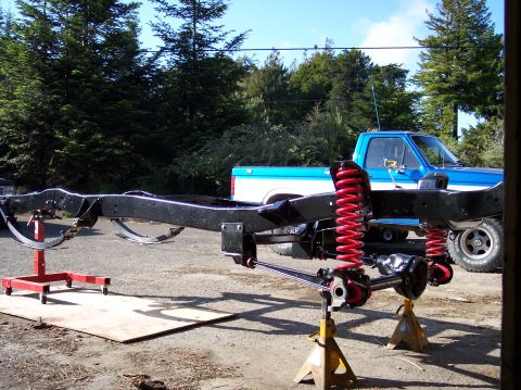 1977 Ford F-150 - The chassis of a 1977 Ford F-150 pickup truck, red suspension springs, is shown on jack stands.