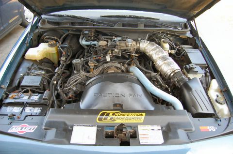 1985 Mercury Grand Marquis - Engine bay of a teal vehicle, showing the V8 engine and various aftermarket parts.