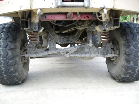 1995 Ford Bronco - The underside of a vehicle shows its heavy-duty suspension and large tires.