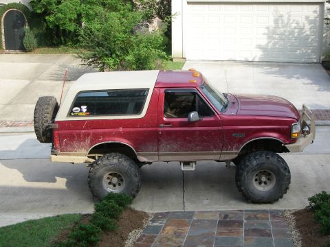 1995 Ford Bronco - This lifted 1995 Ford Bronco is parked in a driveway next to a garage.