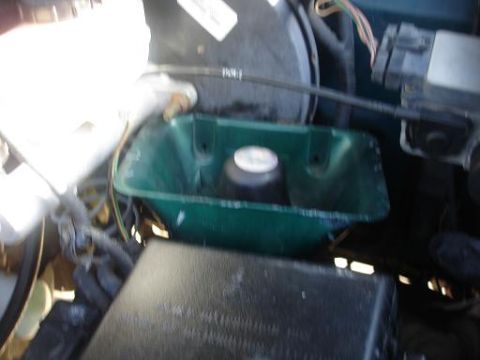 1996 Ford F-150 - Close-up view of a vehicle's engine bay, focusing on a green reservoir and surrounding components.
