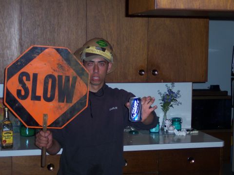 1977 Ford F-150 - A person holds a "SLOW" sign and a can of beer in a kitchen setting.