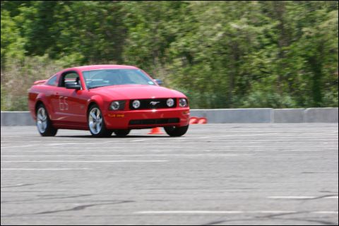 2001 Mercury Grand Marquis - A red Ford Mustang participates in an autocross event on a sunny day.
