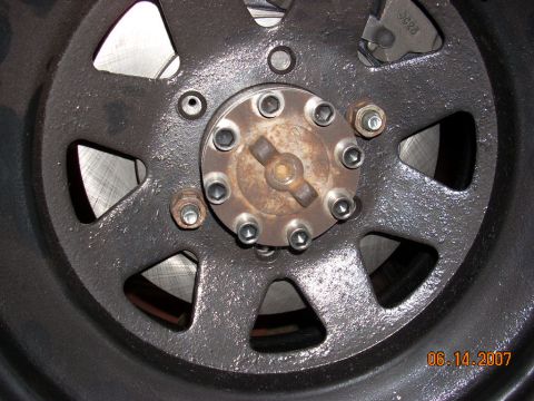 2000 Chevrolet Tahoe - Close-up of a black wheel hub, showing six lug nuts and a rusty center cap. The date 06.14.2007 is visible.