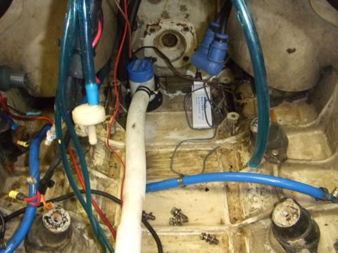 1995 Ford Mustang - Close-up view of a boat's bilge pump and associated plumbing, showing various hoses and electrical connections.