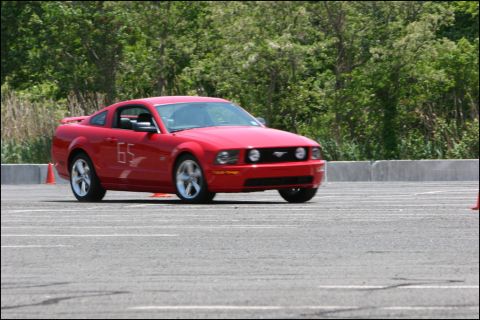 2001 Mercury Grand Marquis - Red Ford Mustang with racing numbers on a track.