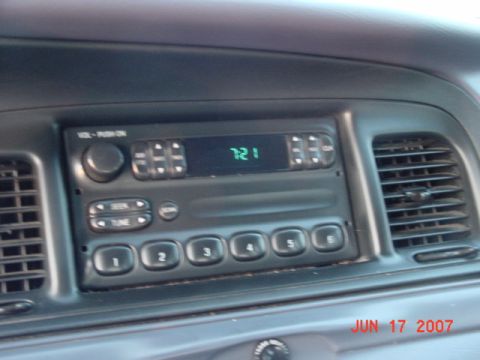 2003 Ford Crown Victoria - Close-up of a car's dashboard, focusing on the radio and air conditioning vents.