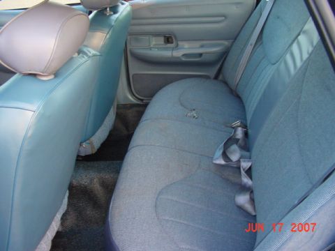 2003 Ford Crown Victoria - Interior view of the rear passenger area of a 2003 Ford Crown Victoria, showing the seats and door panel.