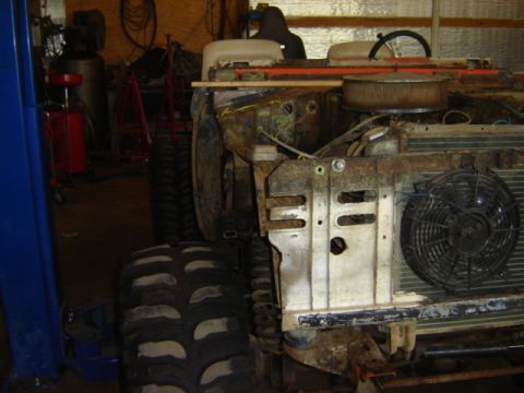 1992 Ford Bronco - This vehicle is in a workshop, undergoing repairs or restoration, with its front end disassembled.