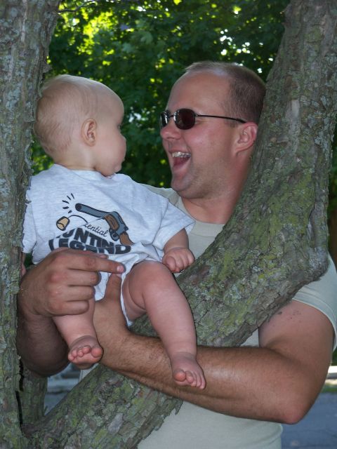 1996 Ford Bronco - A man and a baby share a moment while perched in a tree, with the baby's shirt a graphic of a pistol.