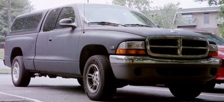 1991 Ford Crown Victoria - This pickup truck, equipped with a camper shell, is shown from the front 3/4 angle. Another vehicle is partially visible behind it.