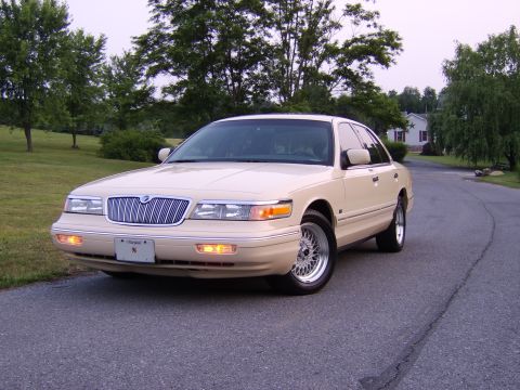 1996 Mercury Grand Marquis - A 1996 Mercury Grand Marquis is shown from the front three-quarter view on a suburban street.