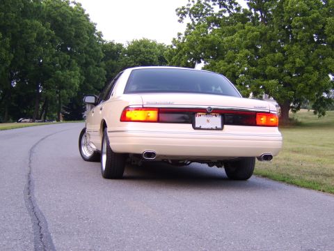 1996 Mercury Grand Marquis - 1996 Mercury Grand Marquis seen from the rear on a paved road with trees.