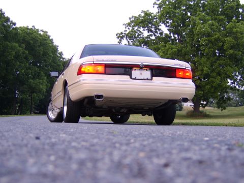 1996 Mercury Grand Marquis - Rear view of a 1996 Mercury Grand Marquis parked on an asphalt road with trees in the background.