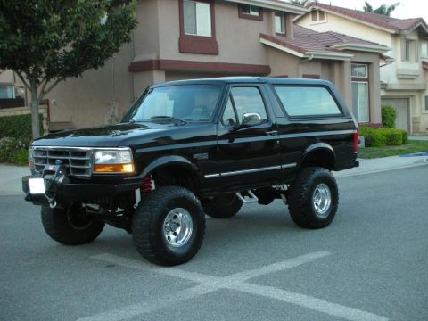 1996 Ford Bronco - A black 1996 Ford Bronco is parked on a suburban street.